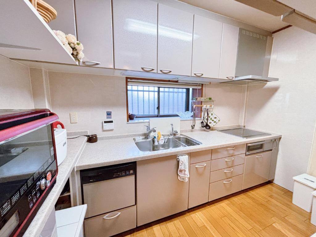a kitchen with white cabinets and a sink at 桜の宿-大阪城Osaka castle-105m2 private-5Way access-KIX USJ 難波心斎橋 Direct in Osaka