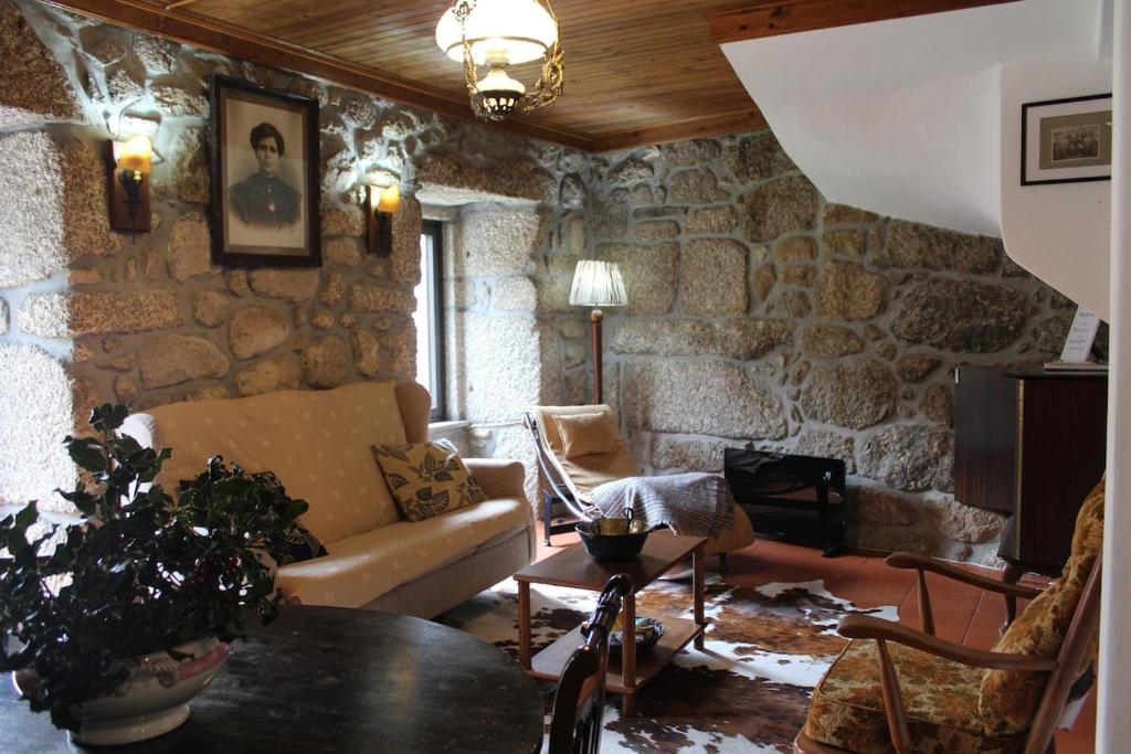 ein Wohnzimmer mit einer Steinmauer in der Unterkunft Casa da Laura - Um refúgio na Serra da Estrela in Alvoco da Serra