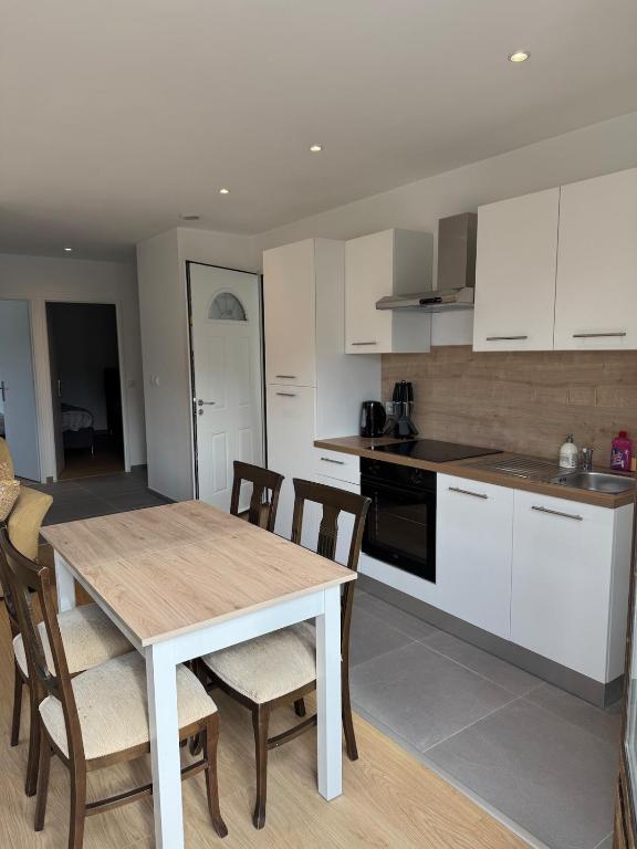 une cuisine et une salle à manger avec une table et des chaises dans l'établissement Appartement T3 rénové cœur de St Priest Parking Privé, à Saint-Priest