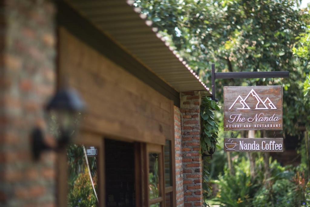 a sign on the side of a building with a sign at The Nanda Resort in Ban Huai Salok