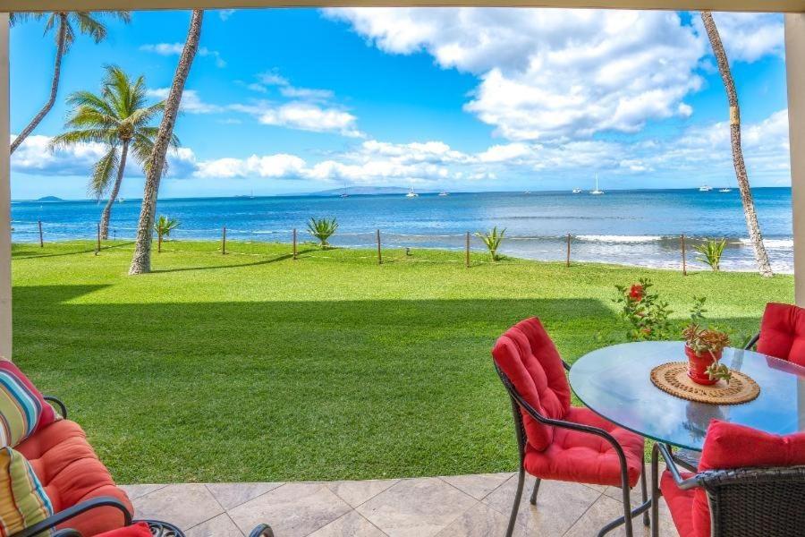 a patio with a table and chairs and the ocean at SUGAR BEACH RESORT, #131 condo in Kihei