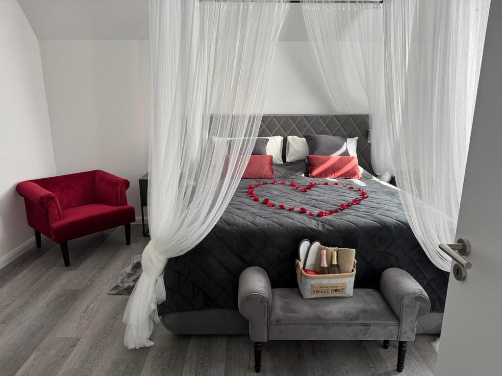 a bedroom with a bed and a red chair at Romantik-Wohnung - Auszeit-Momente mit Sauna in Syke
