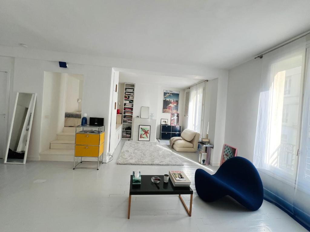 - un salon avec une table et une chaise bleue dans l'établissement cosy design apartment Paris, à Paris