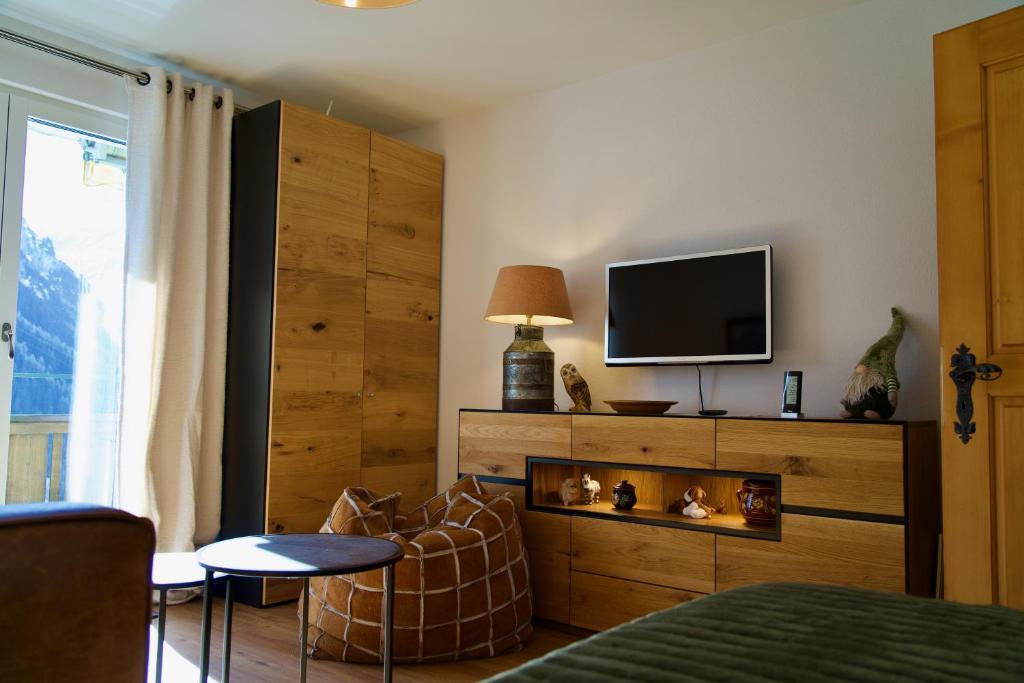 a bedroom with a tv and a couch and a bed at Chalet zur Höhe in Grindelwald