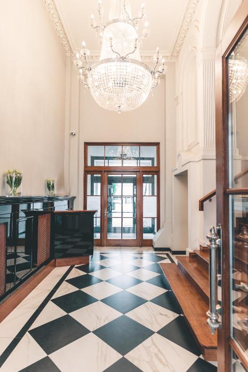 a lobby with a checkered floor and a chandelier at Fortune boutique old town in Poznań
