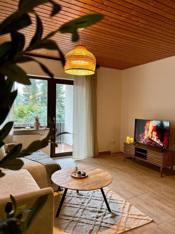 a living room with a table and a tv at Appartement 32 in Triberg