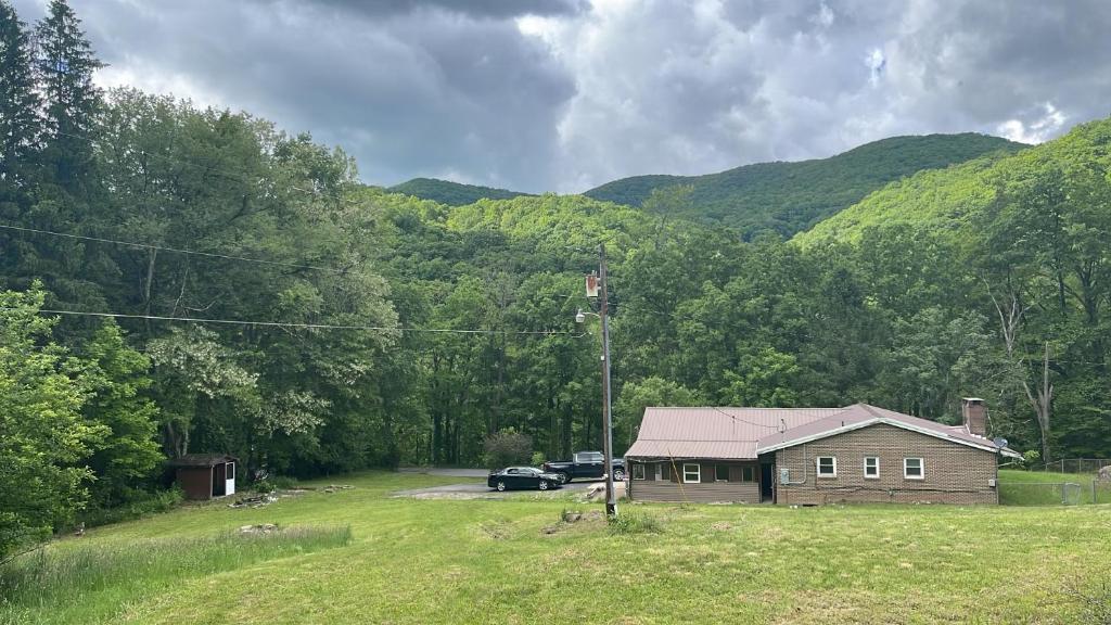 a house in a field with mountains in the background at CampRV Main Lodge in Elkins