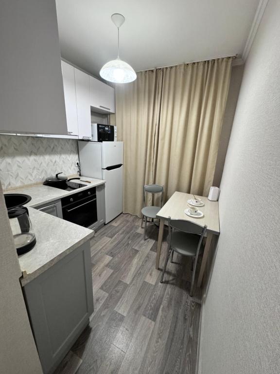a small kitchen with a table and chairs in it at Квартира 43 in Karagandy