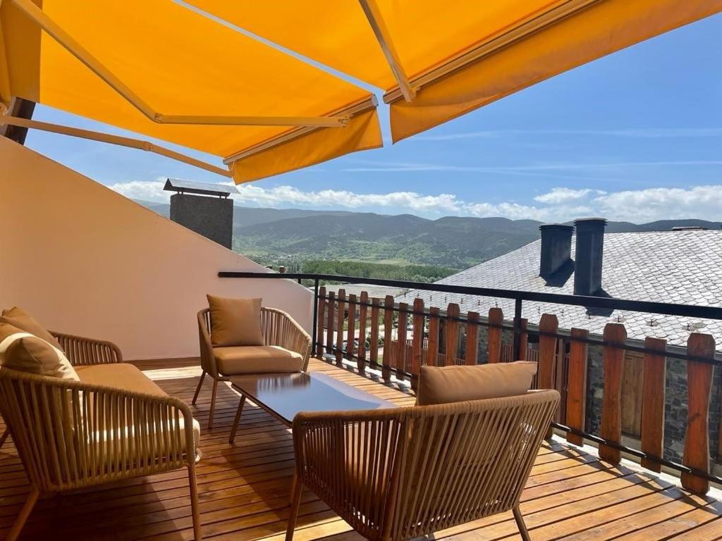 a patio with chairs and a table on a balcony at Magnifico ático con vistas, parking y piscina in Puigcerdà