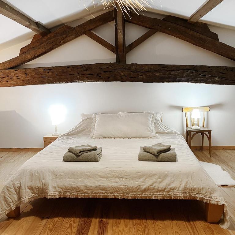 une chambre avec un grand lit avec deux serviettes dessus dans l'établissement Maisonnette - LA CLOCHETTE, à Lugon et l’Ile du Carney