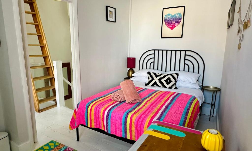 a bedroom with a bed with a colorful blanket at Zen Beach House in Kent