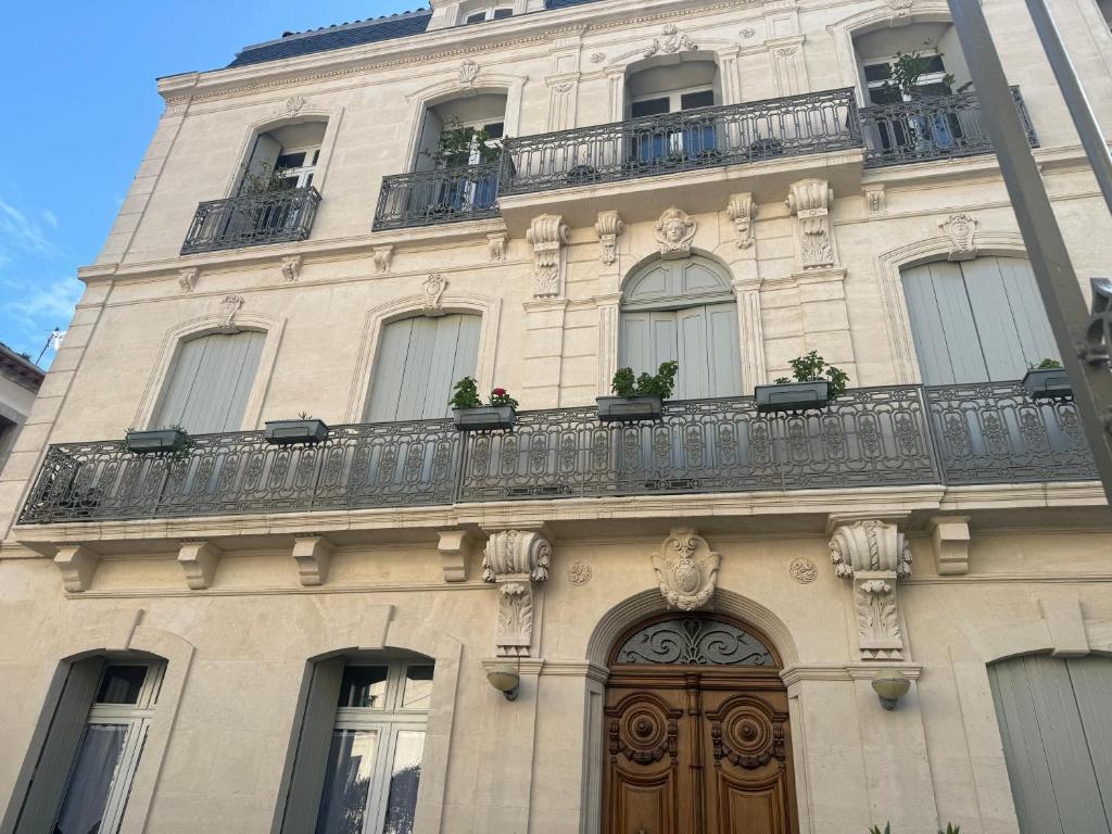 - un bâtiment avec un balcon et une porte en bois dans l'établissement Studio 30 m2 avec jardin dans maison de maître, à Béziers
