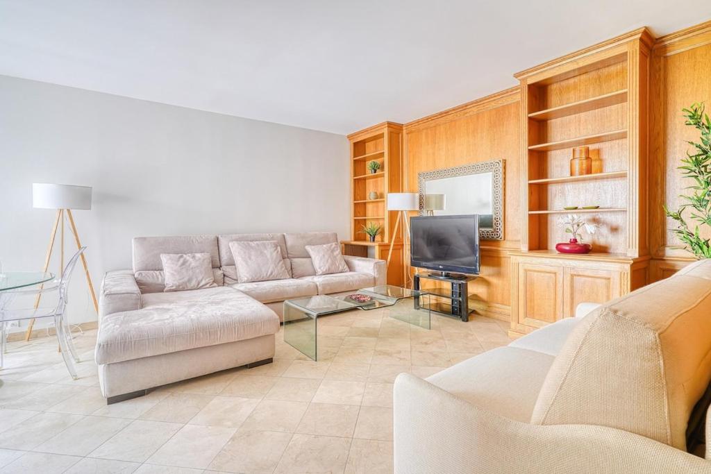 un salon avec un canapé et une télévision dans l'établissement Spacious & Cozy Apartment - Trocadero Passy, à Paris