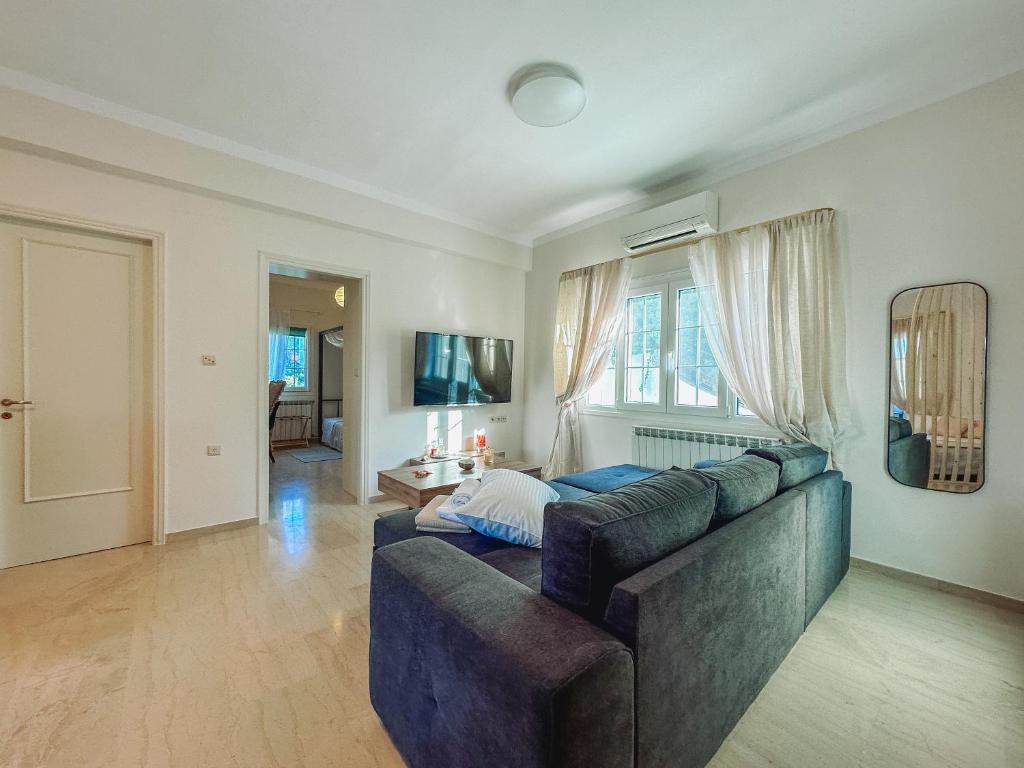 a living room with a couch and a television at Sea Lullaby in Drymonas