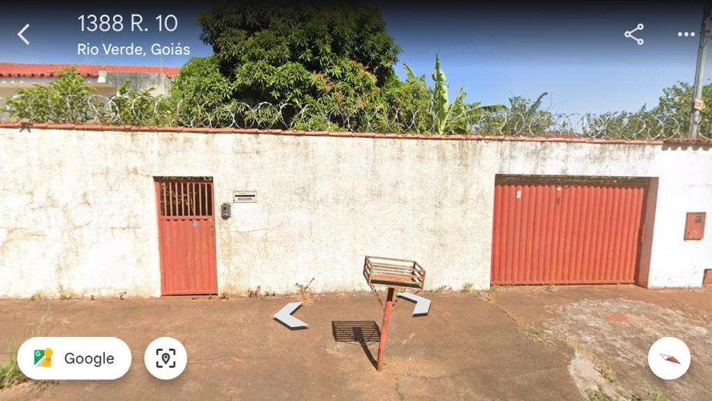 a bench in front of a building with red doors at Tecnoshow 2025 - casa in Rio Verde