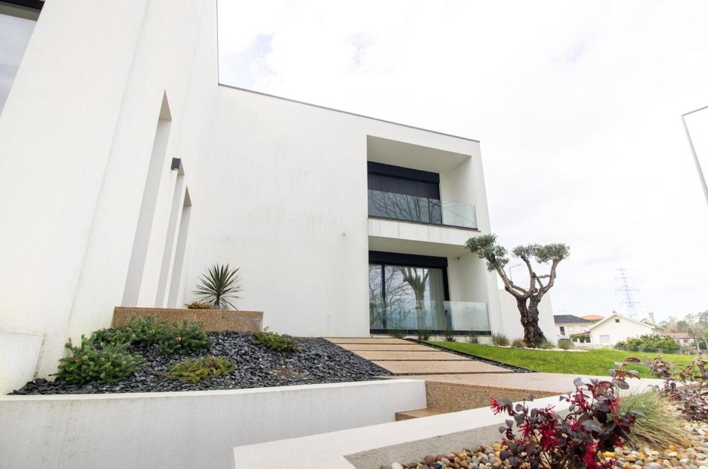 a white house with a courtyard with plants at Villa with Pool Casa Sol Poente by casaporto207 in Vila Verde