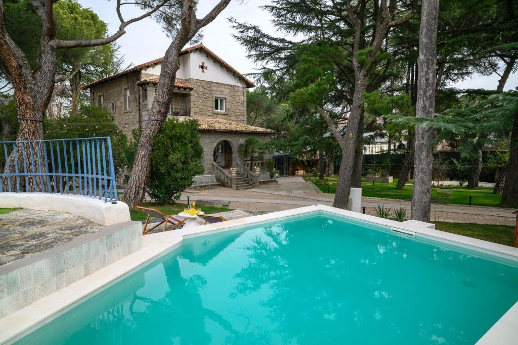 a blue swimming pool in front of a house at Espacio 1902 in Collado-Villalba