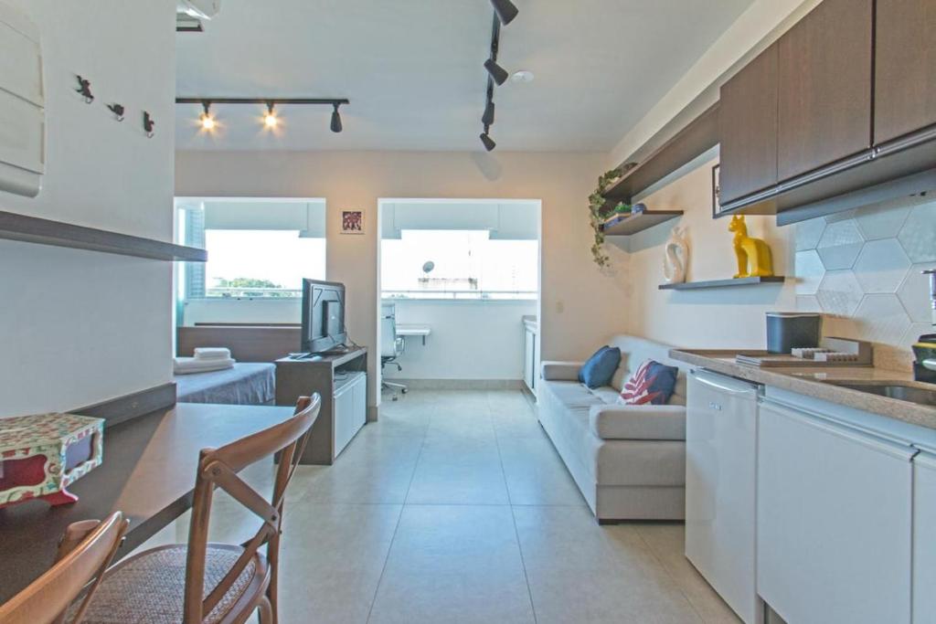a kitchen and living room with a couch and a table at Studio 517 com Garagem - Perto do Consulado e Autódromo de Interlagos in Sao Paulo