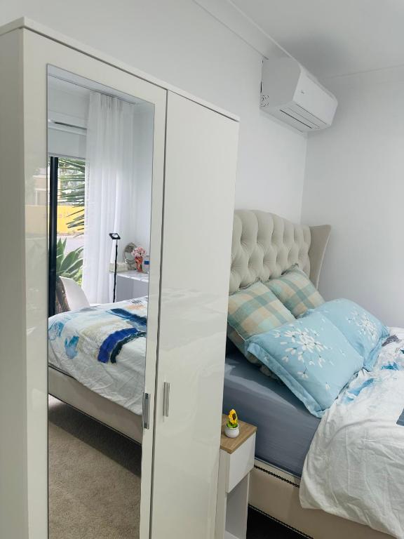 a bedroom with a bed and a mirror at Premium Snooze Queen Bed Petite Room in Caroline Springs