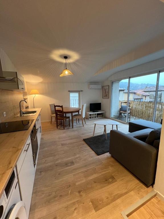 une cuisine et un salon avec un canapé et une table dans l'établissement Appartement rénové avec terrasse, à Anduze
