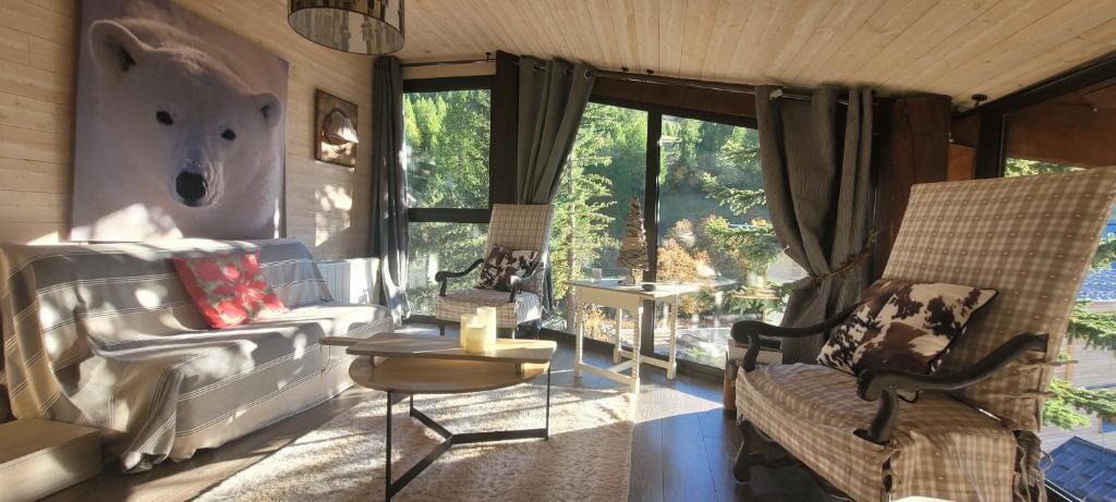 un salon avec un canapé et une chaise dans l'établissement Appartement de montagne, CHARME et calme au pied des pistes, à Enchastrayes