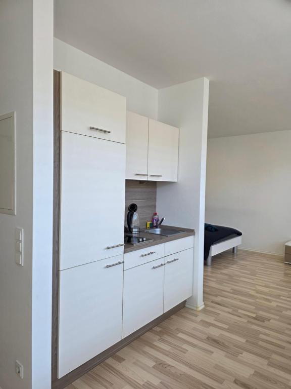 a white kitchen with a sink and a refrigerator at Ganz Apartments in Fürth