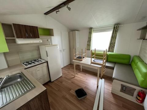 une petite cuisine avec un canapé et une table dans l'établissement Mobile home 6 personnes 1semaine minimum juillet août, à Saint-Hilaire-de-Riez