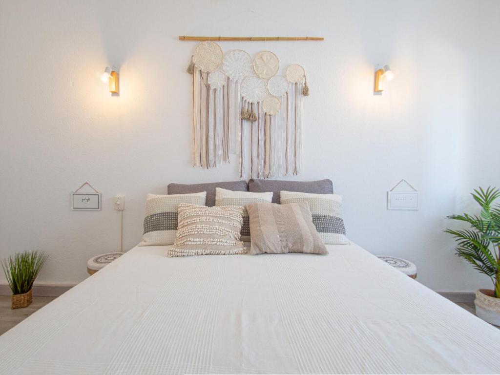 a white bed with pillows on it in a room at Boho house, Albufeira in Albufeira
