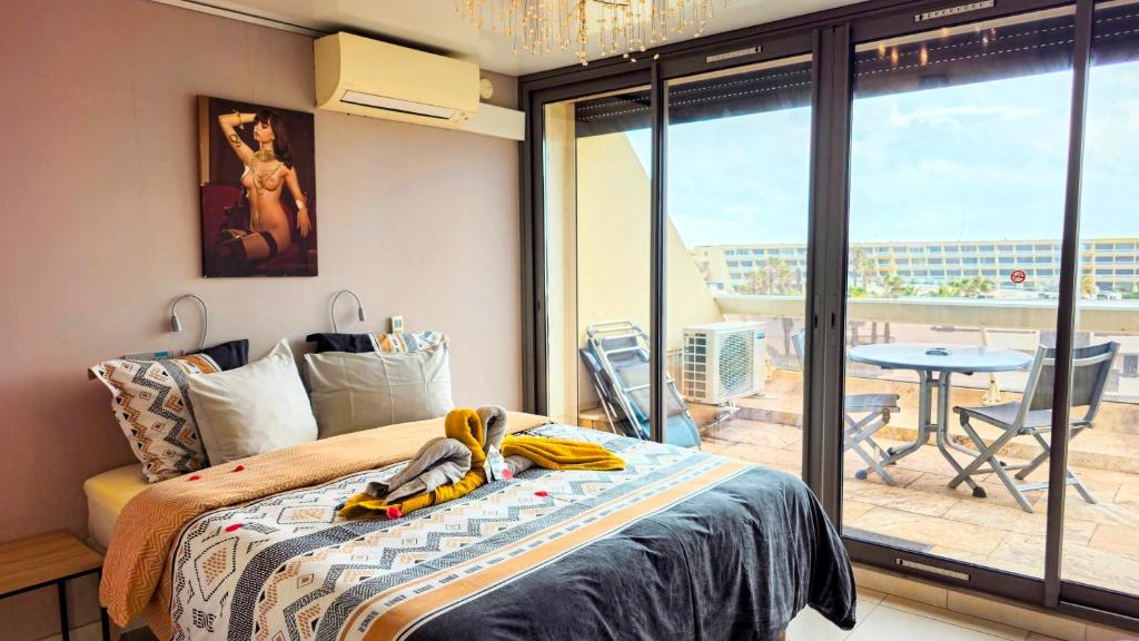 une chambre avec un lit et un balcon avec une table dans l'établissement CapSexy Heliopolis Sea View Naturist Village, au Cap d'Agde