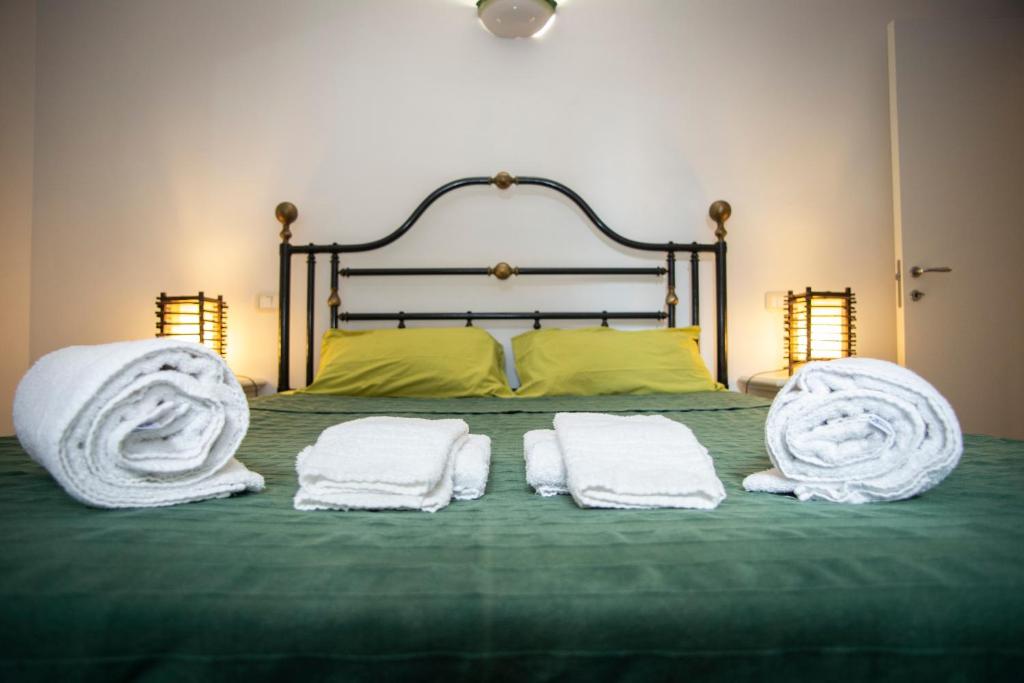 łóżko z 2 poduszkami i ręcznikami w obiekcie Agriturismo Serignano alle Rocchette w mieście Castiglione della Pescaia