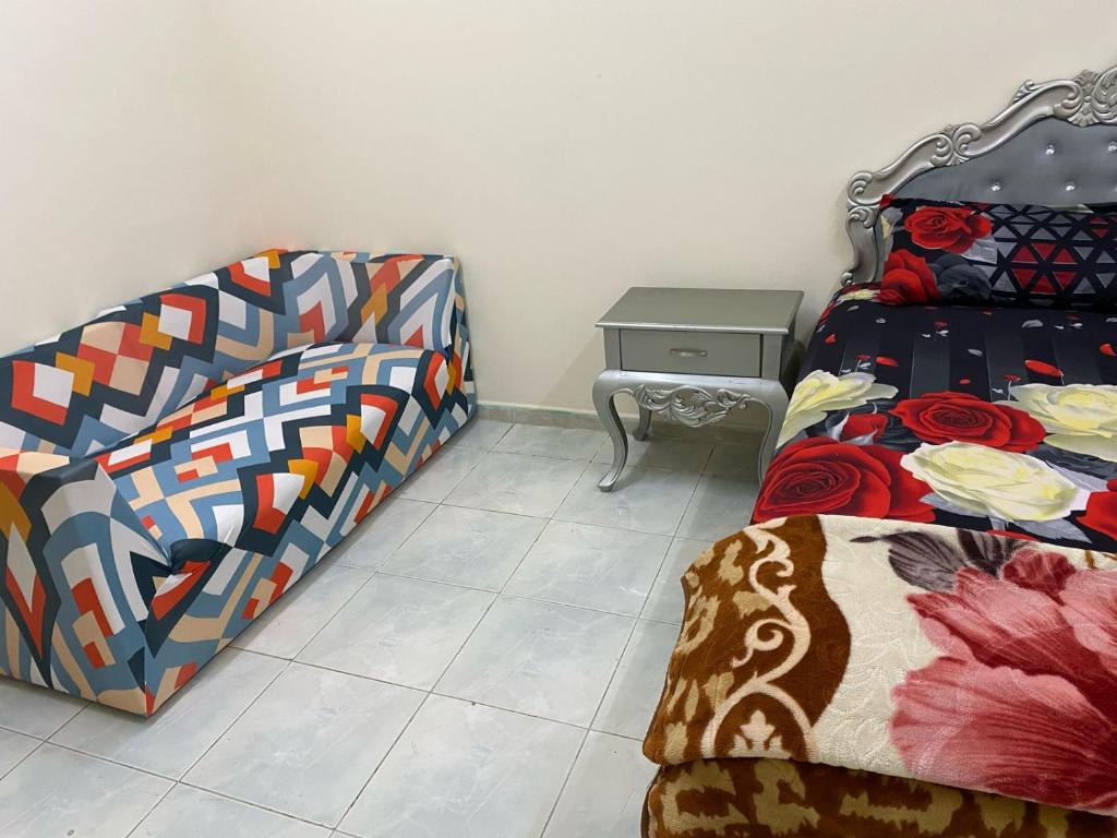 a bedroom with a bed and a nightstand and a bed and a bedskirts at AAP KA APPNA ROOm2 in Sharjah