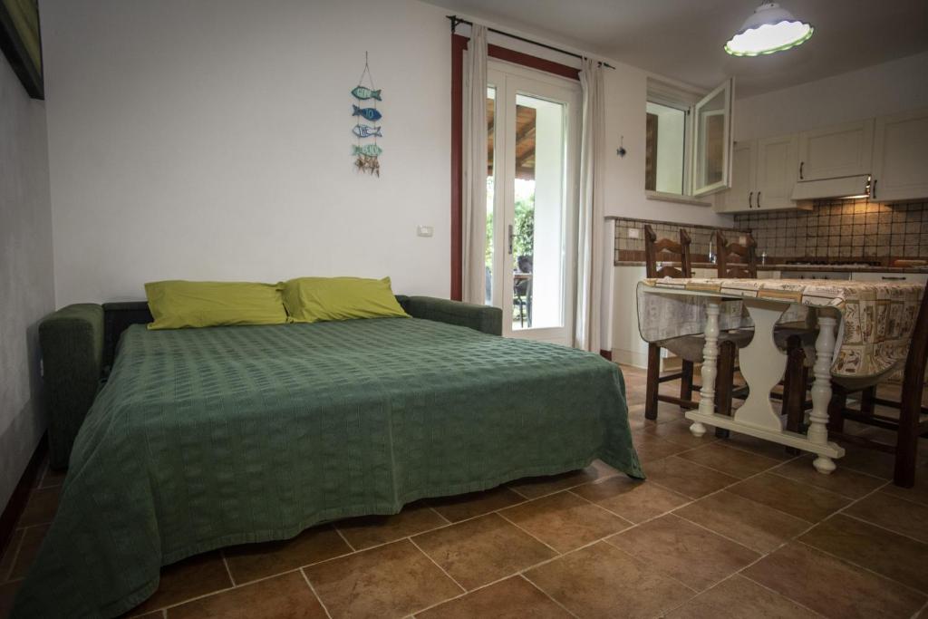 sypialnia z łóżkiem i kuchnia ze stołem w obiekcie Agriturismo Serignano alle Rocchette w mieście Castiglione della Pescaia