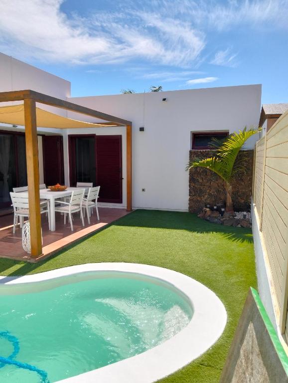 a swimming pool in the backyard of a house at Casa Vacacional Villa Liberty in Corralejo