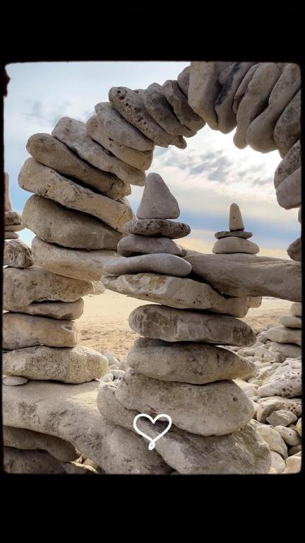 une pile de rochers avec un cœur blanc au-dessus dans l'établissement Joli appartement à la mer, à La Tranche-sur-Mer