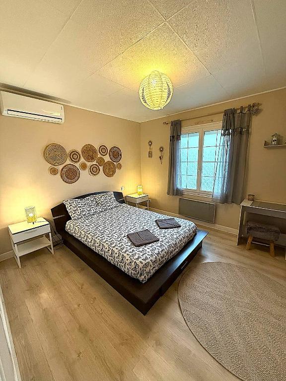 a bedroom with a bed and two tables in it at Les mésanges, 10m Zoo de Beauval, climatisation in Noyers-sur-Cher