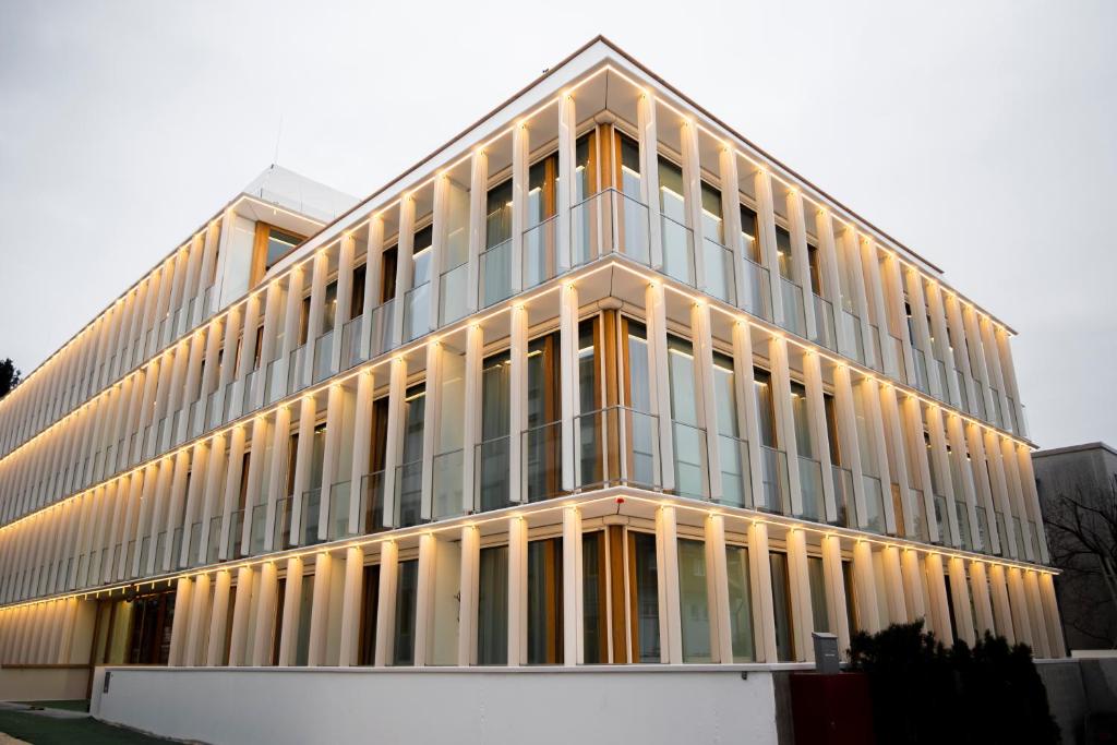 菲尔德施塔特Das Kaya Hotel Stuttgart Airport Messe的一座高大的玻璃建筑,有很多窗户