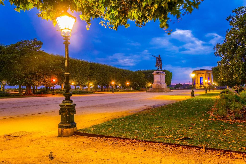 a street light in a park at night at Hotel d'Aragon - Place de la Comédie in Montpellier