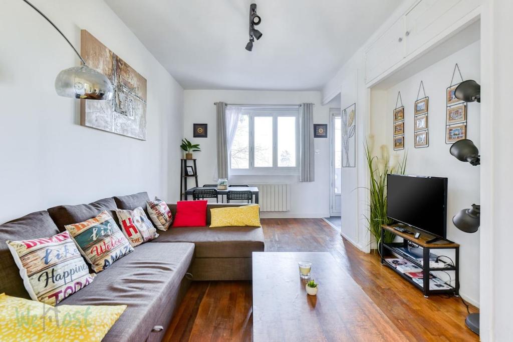 un salon avec un canapé et une télévision dans l'établissement T3 étoilé Meuble de tourisme, à Lyon