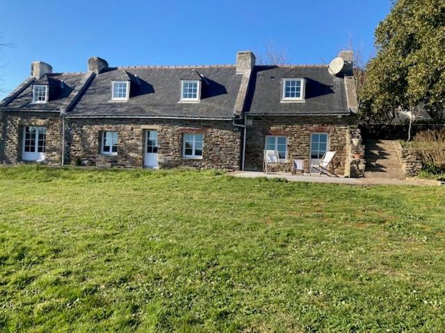 une grande maison en pierre sur un champ herbeux dans l'établissement Gite Mer & Vallons à proximité plage des Grands Sables, à Locmaria