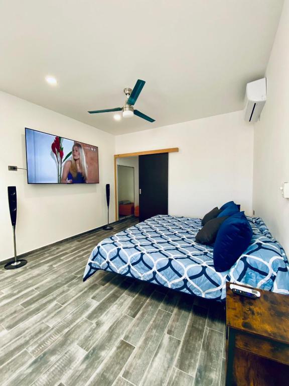 a bedroom with a bed and a flat screen tv at Departamento Arrecife in La Paz
