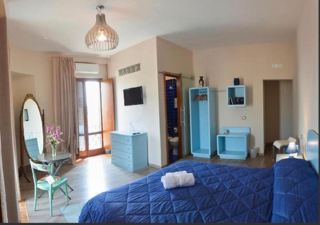 Un dormitorio con una cama azul y un espejo. en FURTURE'Rooms, en Nápoles