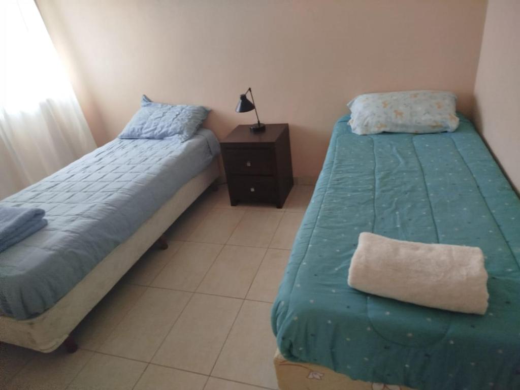 a bedroom with two beds and a night stand with at Encanto de Lozano in Lozano