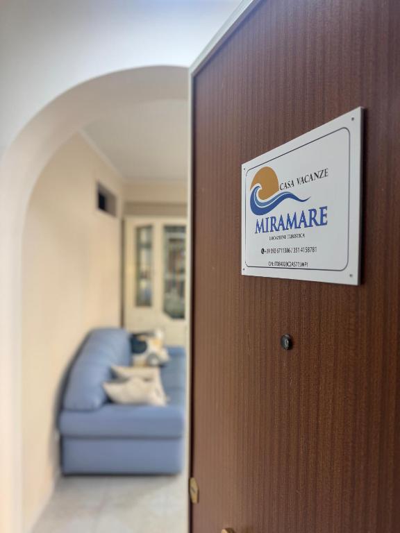a sign on a door with a blue couch at Casa Vacanze Miramare in Porto Empedocle