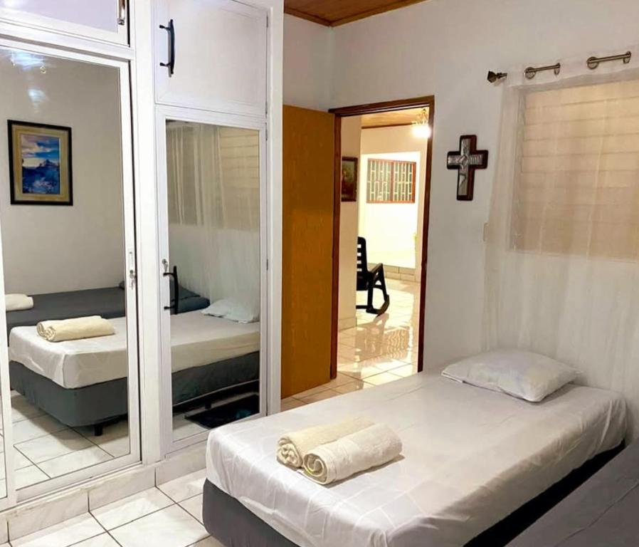 a bedroom with two beds and a mirror at Casa Arcia in Rivas