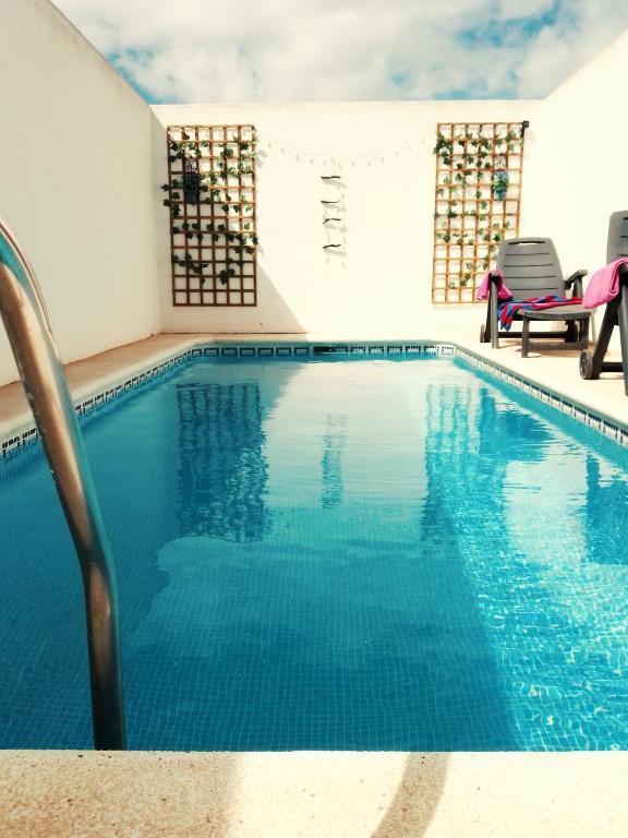 a swimming pool with blue water in a building at Casa Luna in Santiago de la Ribera