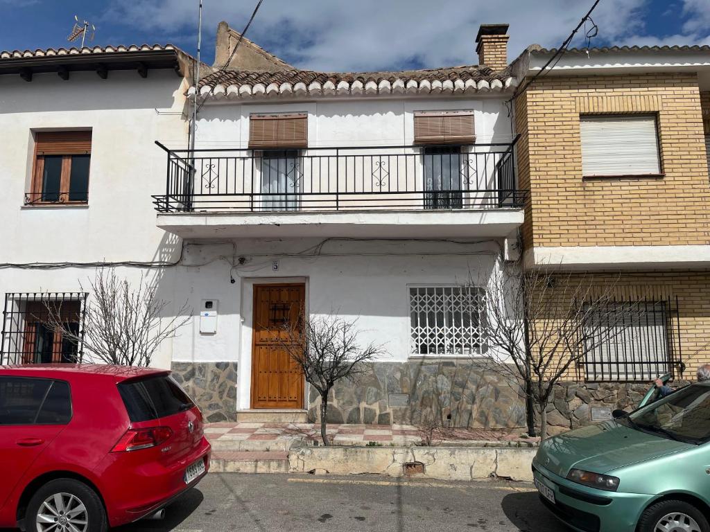 een rood busje geparkeerd voor een huis bij Casa rural Martín in Granada