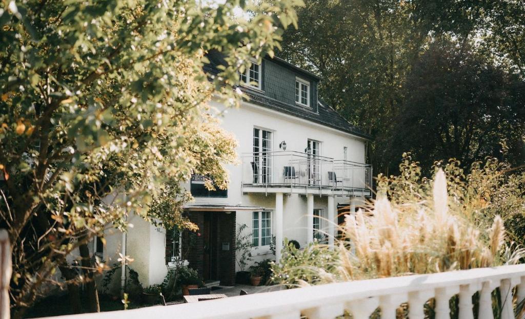 a white house with a balcony on top of it at Pension-Sendis in Herne