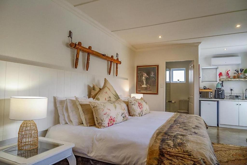 a bedroom with a large bed and a table at The Hedge Cottage in Riebeek-Kasteel