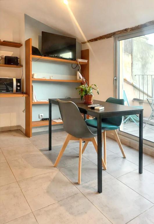 une salle à manger avec une table et des chaises noires dans l'établissement Studio moderne à Aix-en-Provence - 20 m² avec terrasse !, à Aix-en-Provence