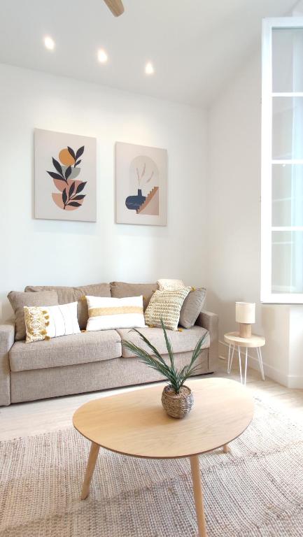 un salon avec un canapé et une table dans l'établissement Studio rénové, vue dégagée et arborée, 700m plage, à Cannes